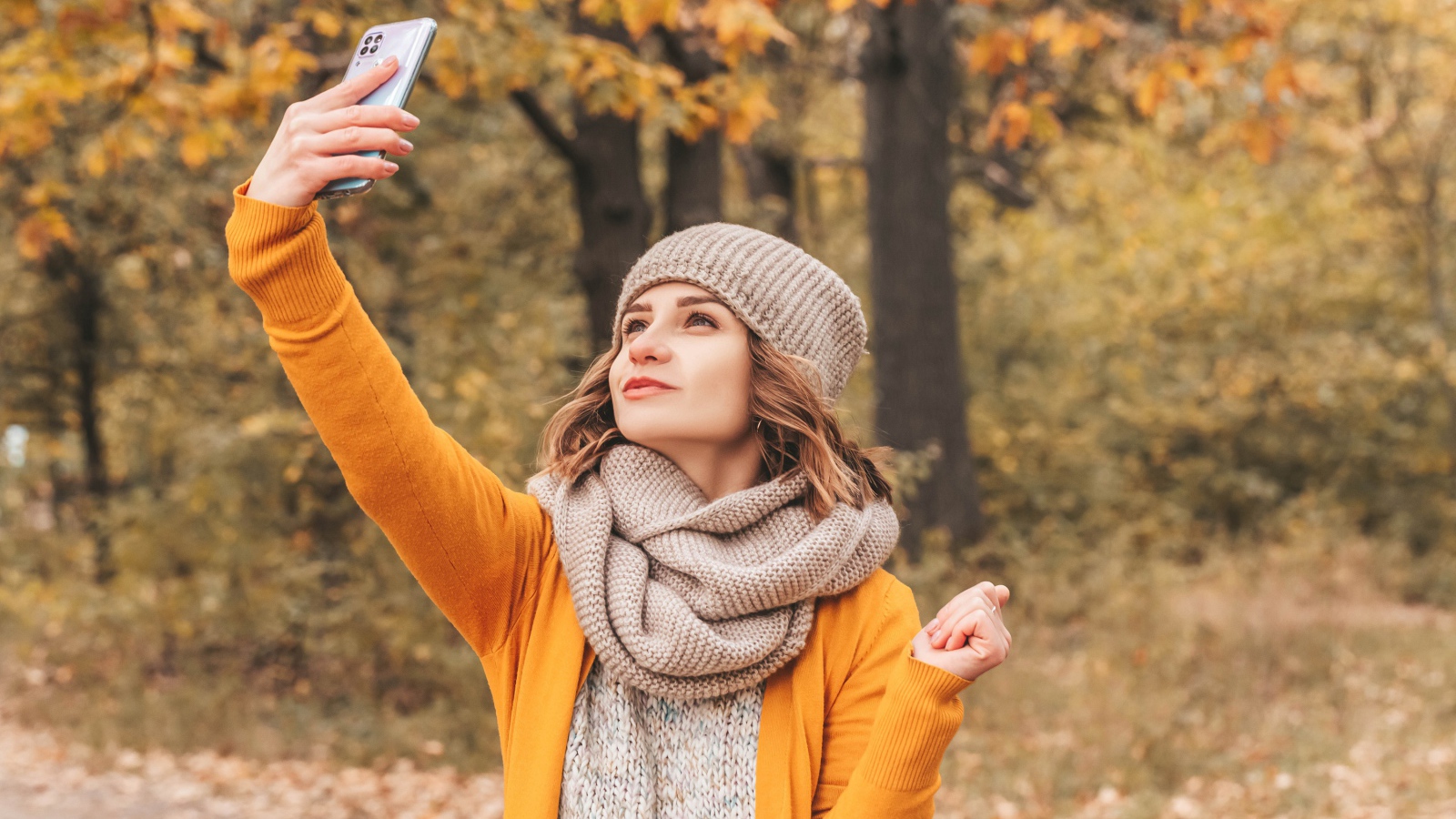 Девушка делает селфи на улице осенью 