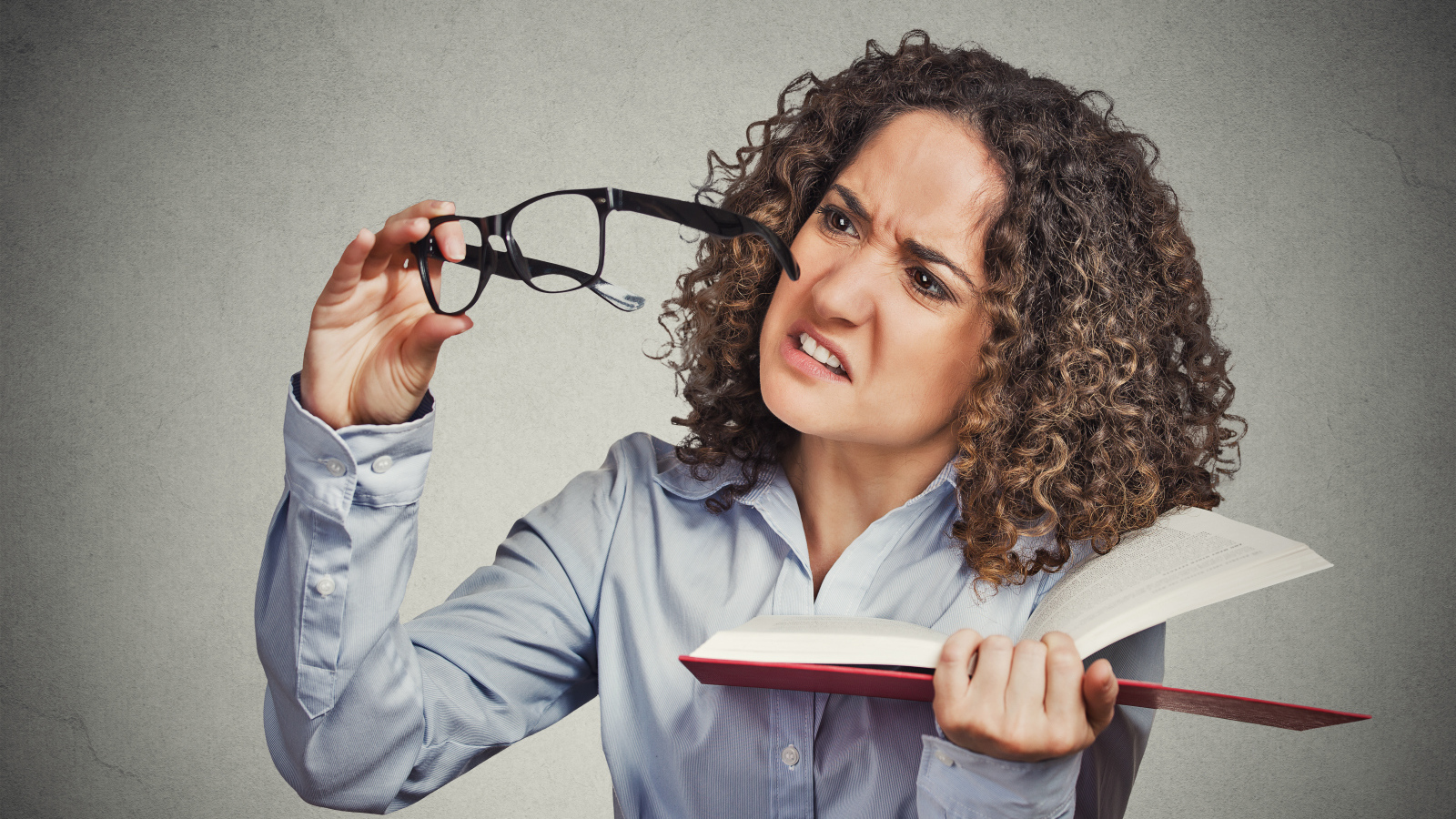 Девушка с книгой с очками в руке