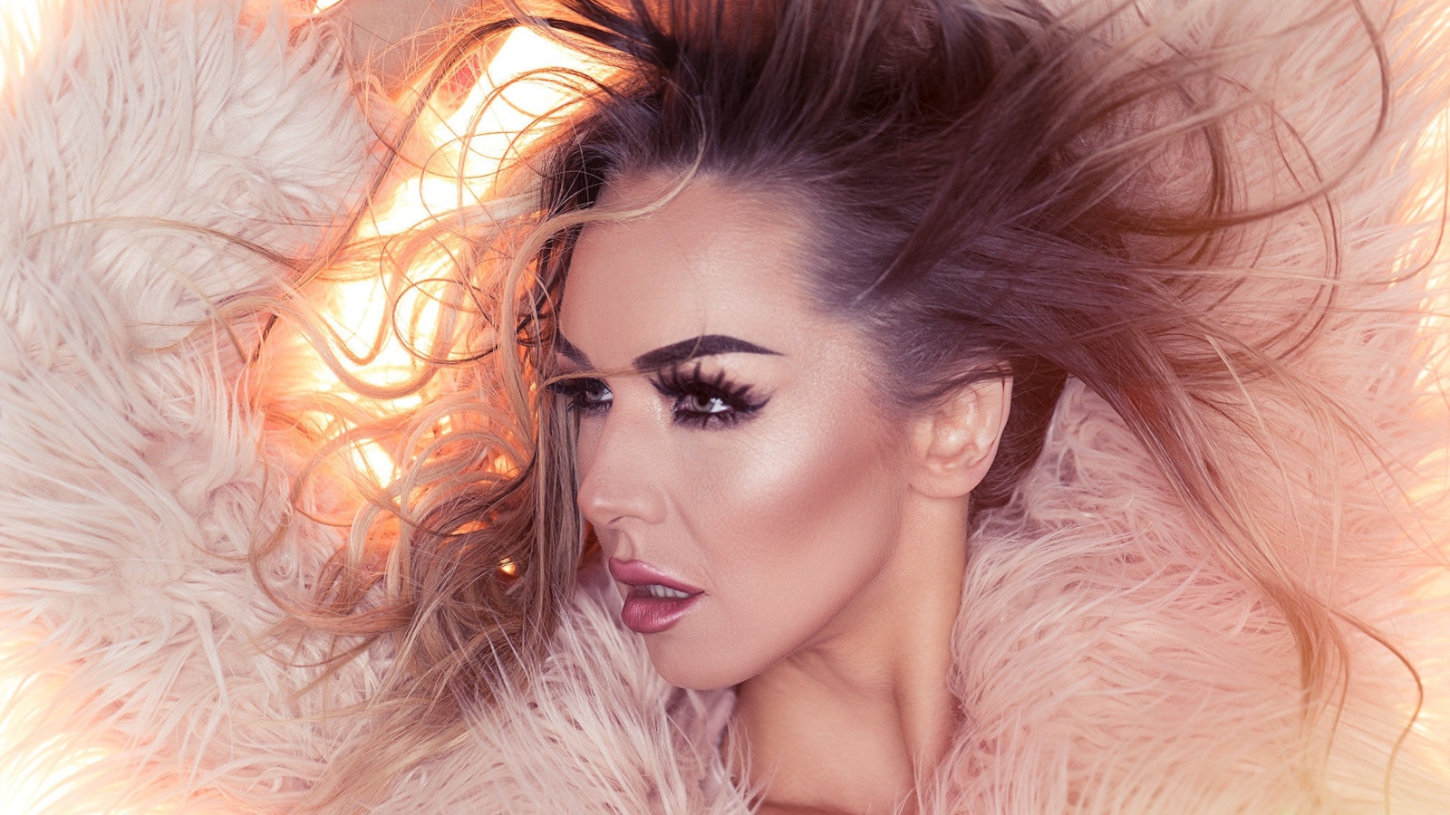 Девушка с распущенными волосами в розовой шубе 