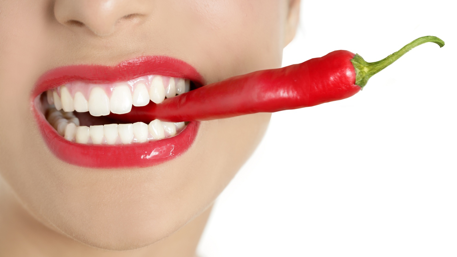 Острый перец во рту у девушки с красивыми белыми зубами 