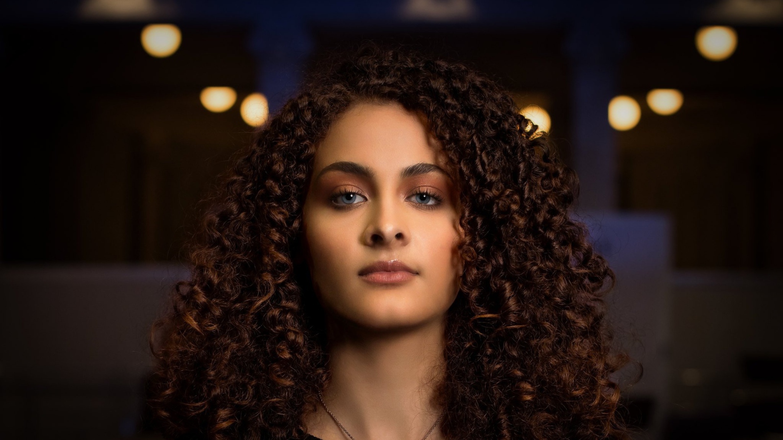 Длинные кудрявые волосы у красивой голубоглазой девушки