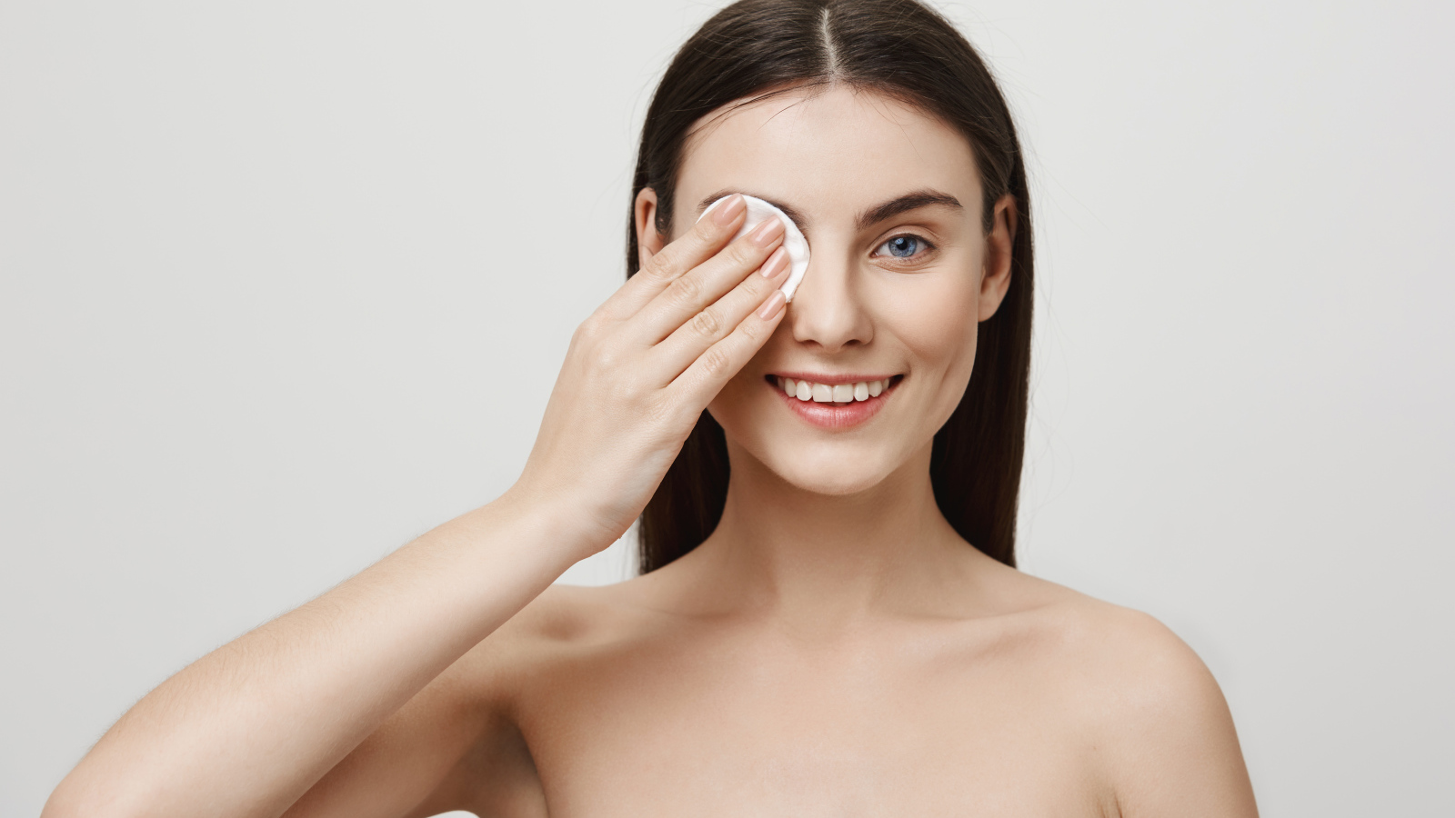 Настоящая голубоглазая девушка снимает макияж с лица