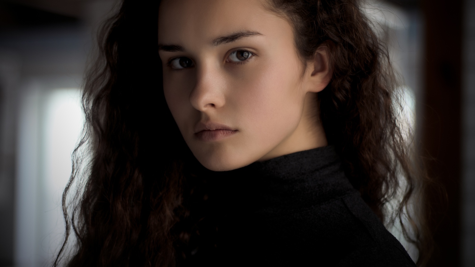 Грустная кареглазая девушка с длинными волосами