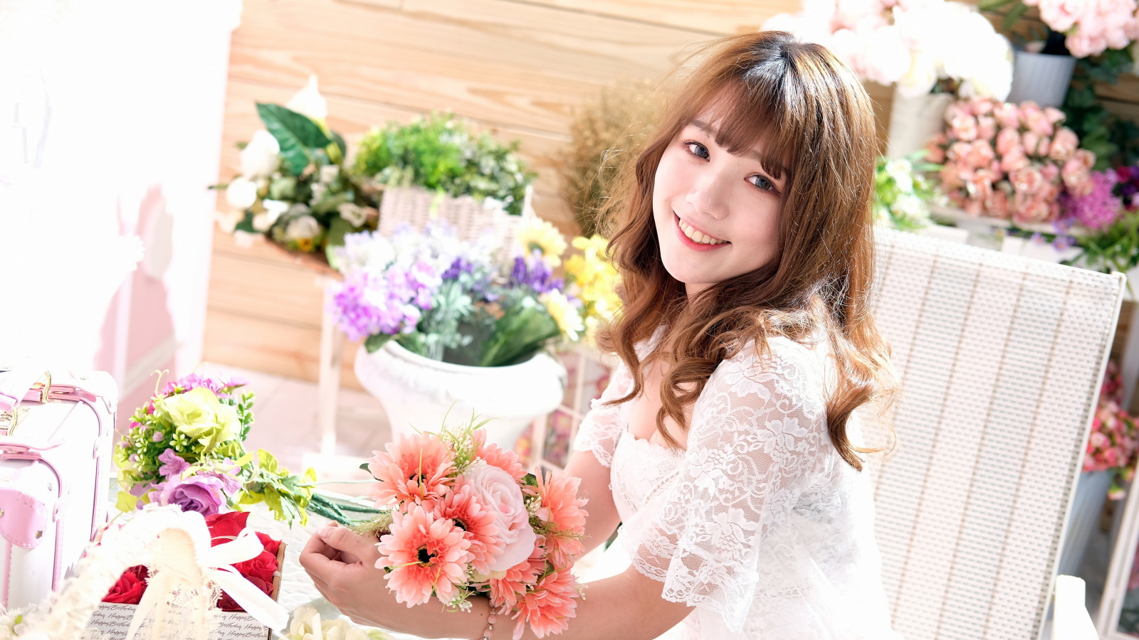 Улыбающаяся девушка азиатка в белом кружевном платье 