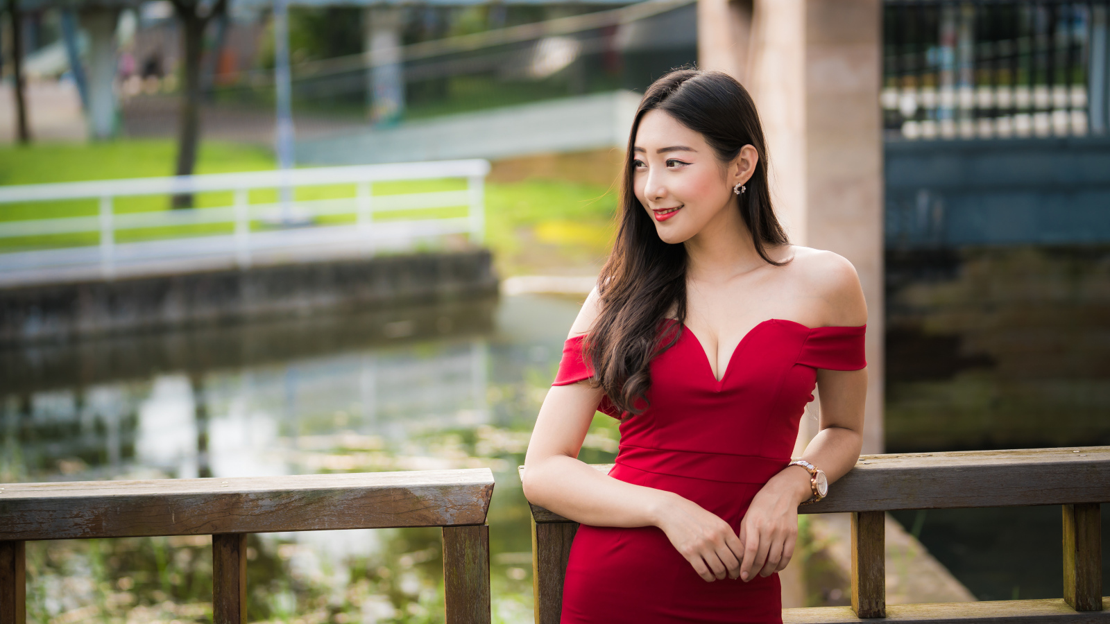 Улыбающаяся девушка в красном платье у перил 