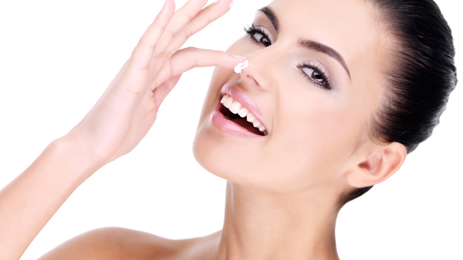 Улыбающаяся девушка мажет крем на нос 