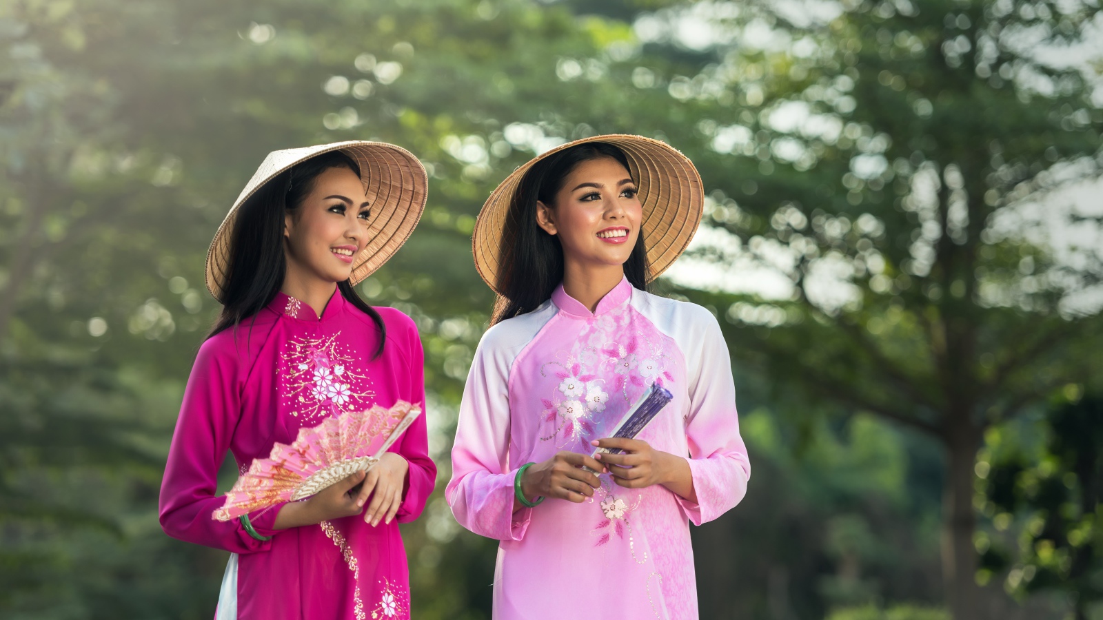 Две девушки азиатки в платьях с веером в руках