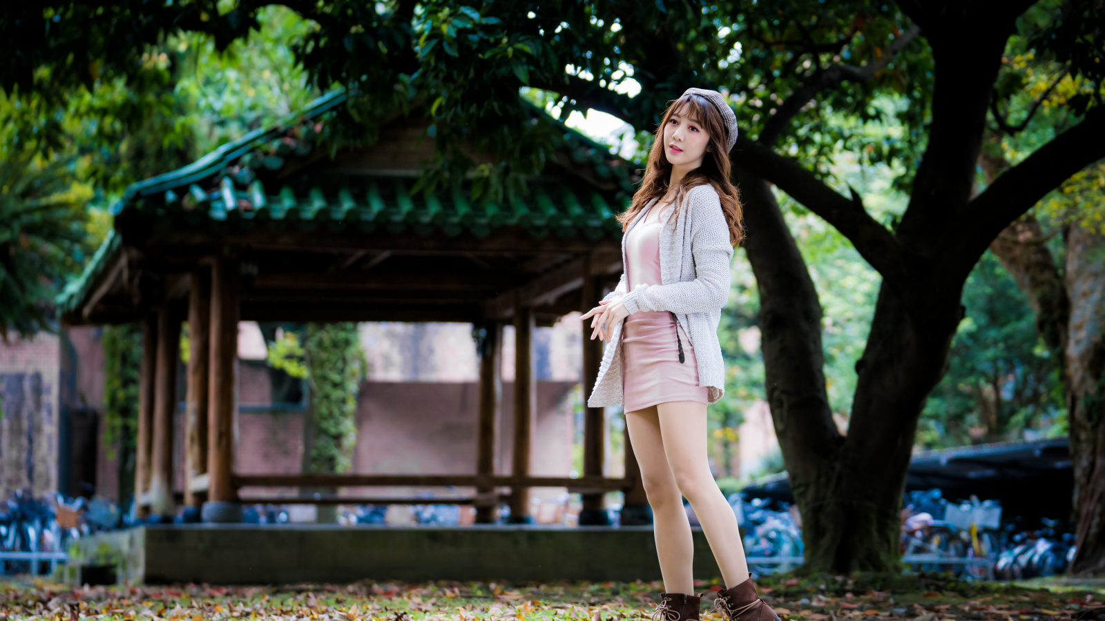 Молодая азиатка в теплой кофте в парке