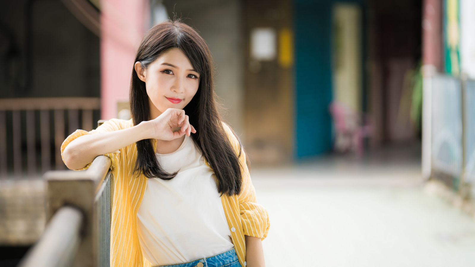 Молодая азиатка в белой майке и полосатой рубашке 