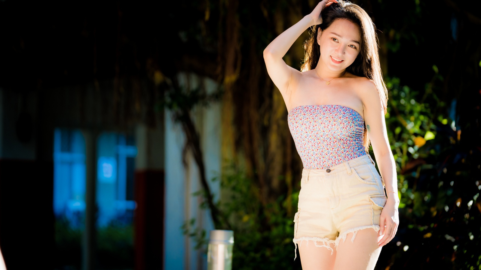 Молодая азиатка в шортах в лучах солнца