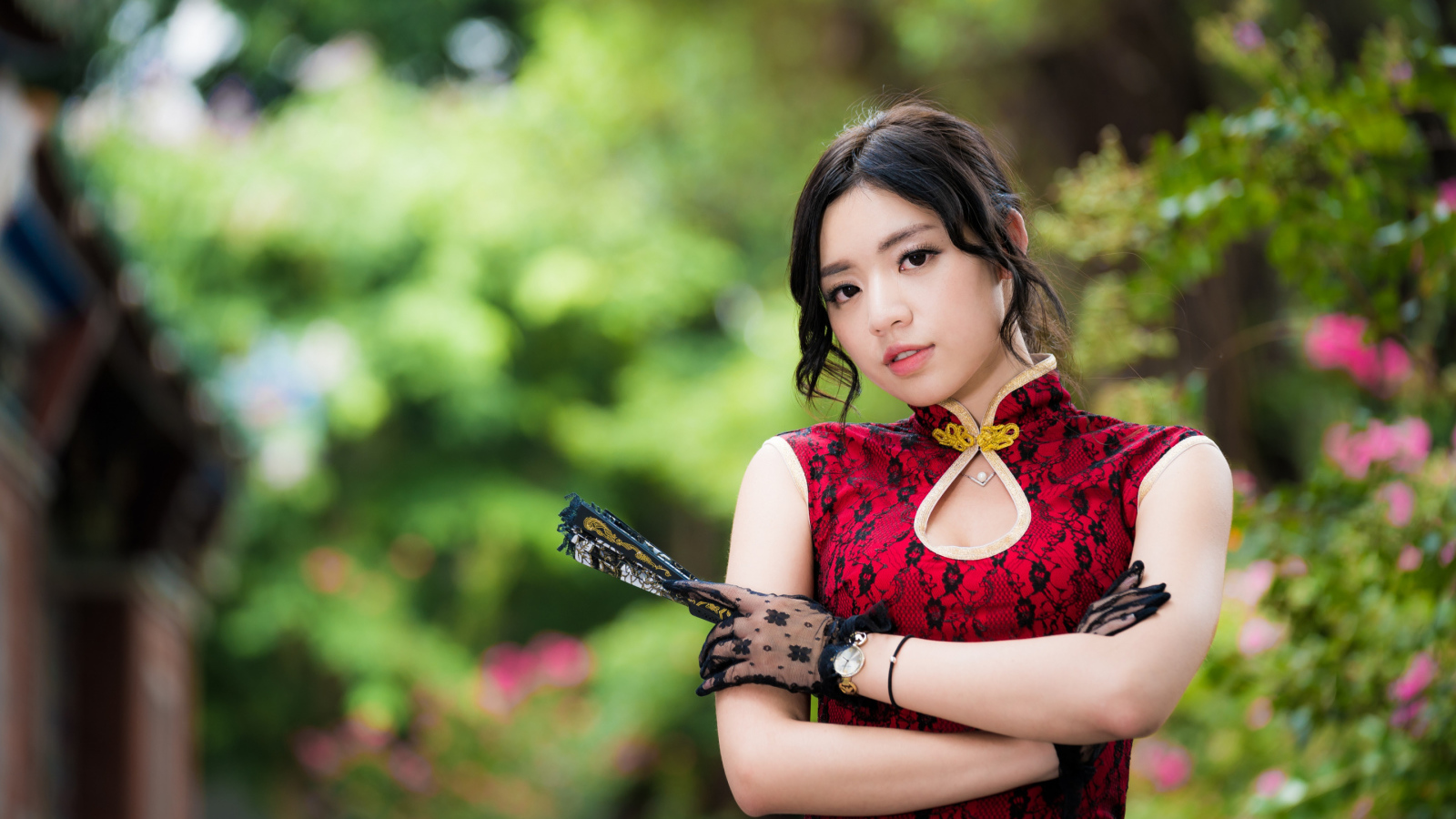 Молодая азиатка в красивом платье с веером в руке