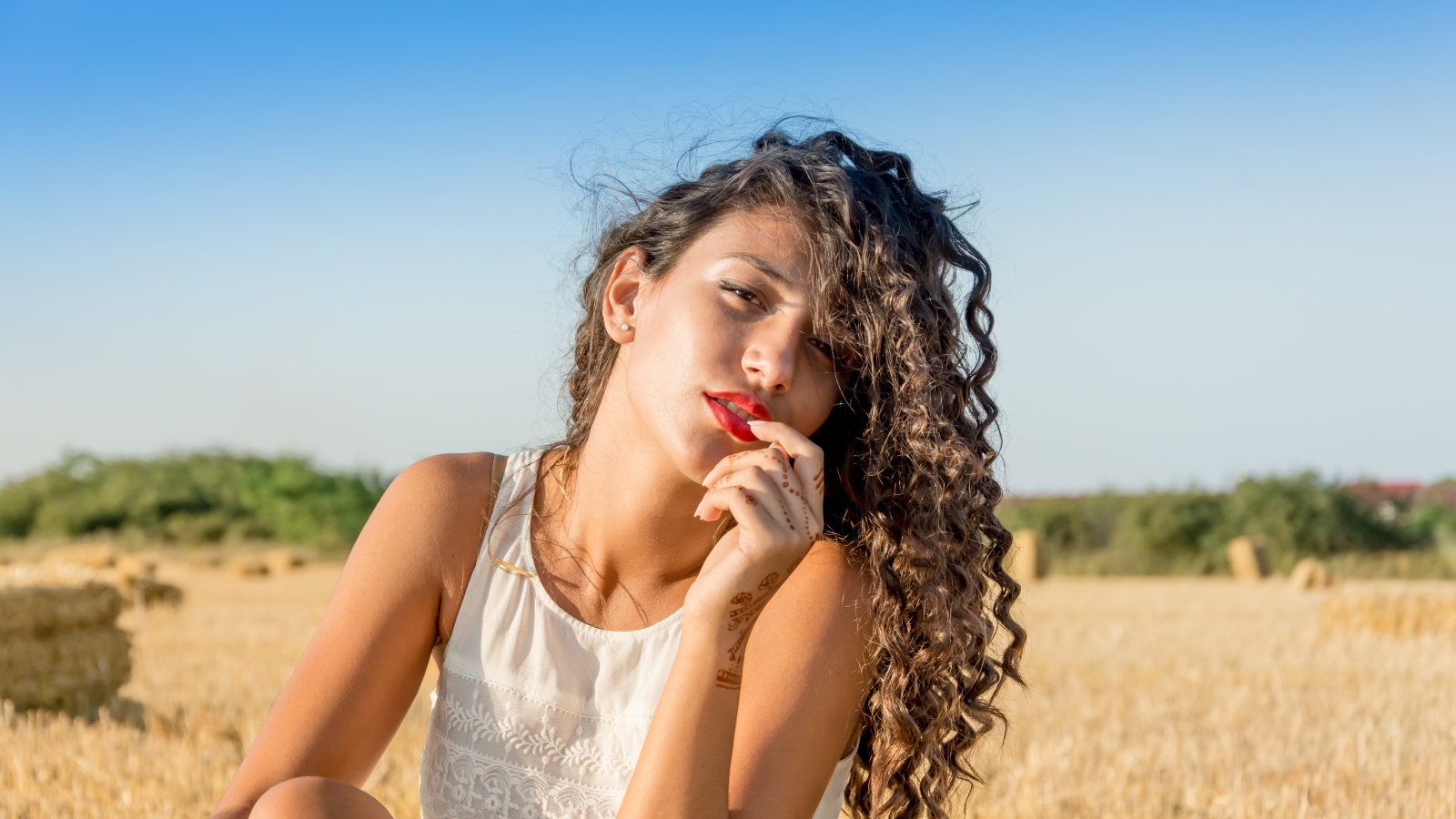 Молодая девушка в белом платье на пшеничном поле