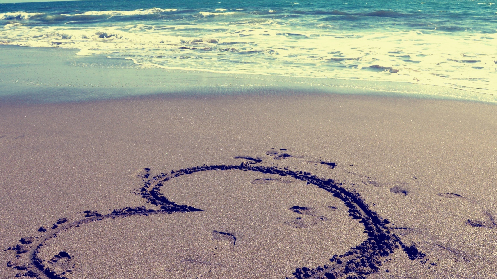 Большое сердце на мокром песке на пляже