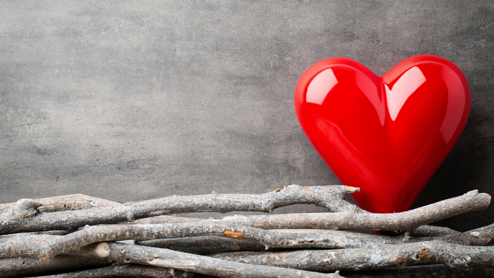 Большое красное сердце на сером фоне с деревянными прутьями