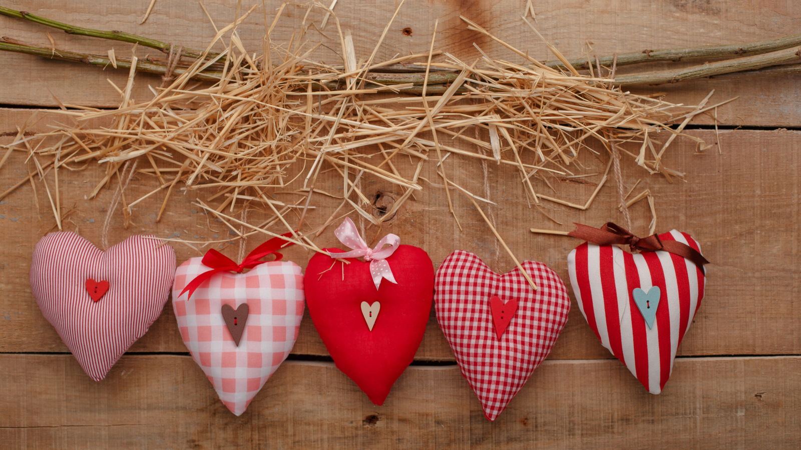 Тканевые сердечки на столе с сеном и веткой