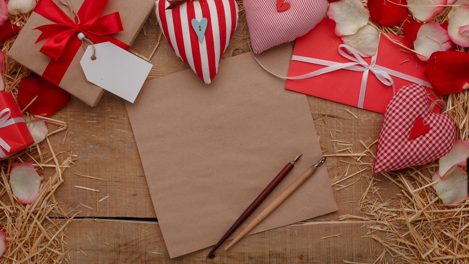 Сердечки из ткани на столе с бумагой и подарками 