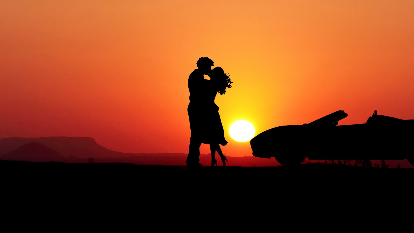 Целующаяся пара на фоне заката с автомобилем