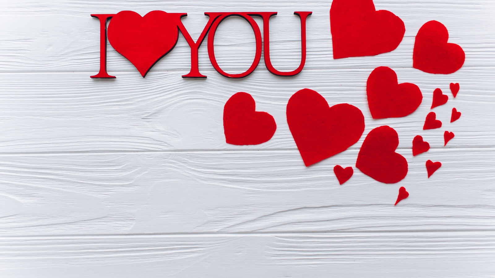 Надпись Я тебя люблю с красными сердечками на столе