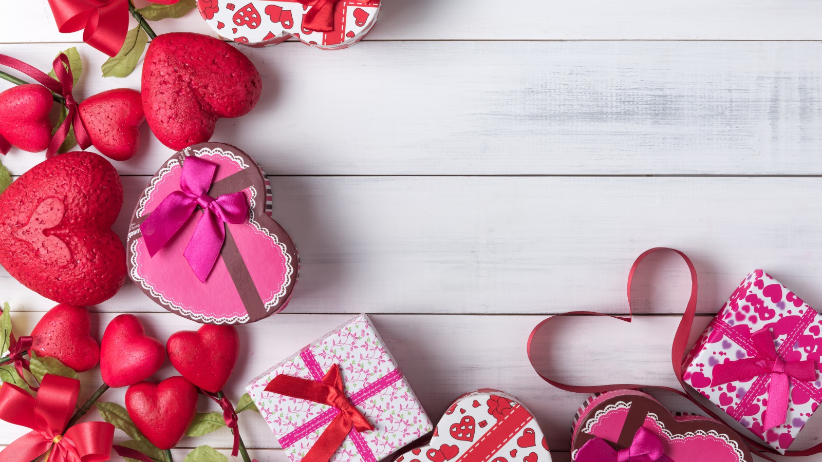 Много подарочных коробок в форме сердца на сером столе 