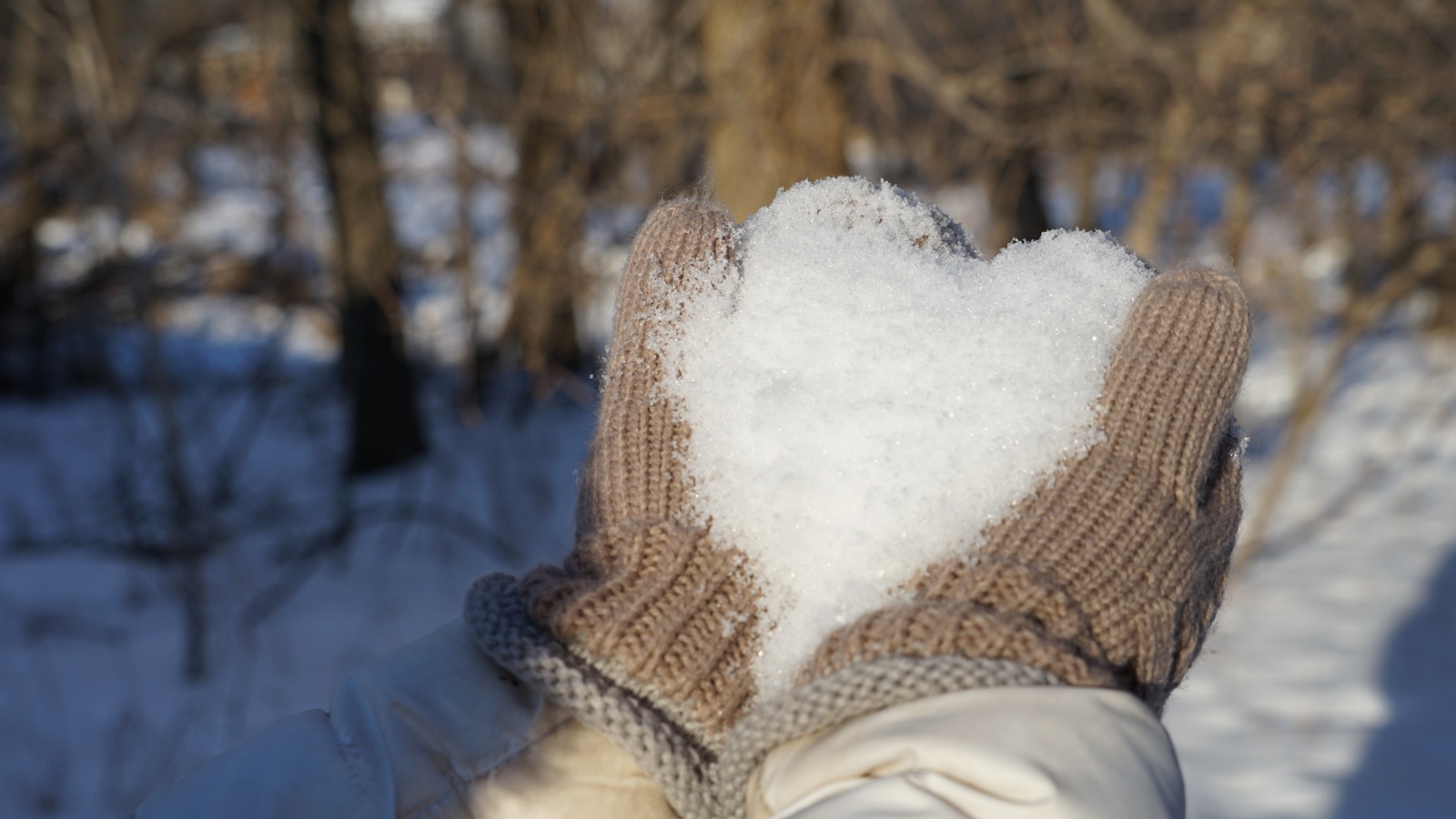 Снег в руках у девушки в перчатках 