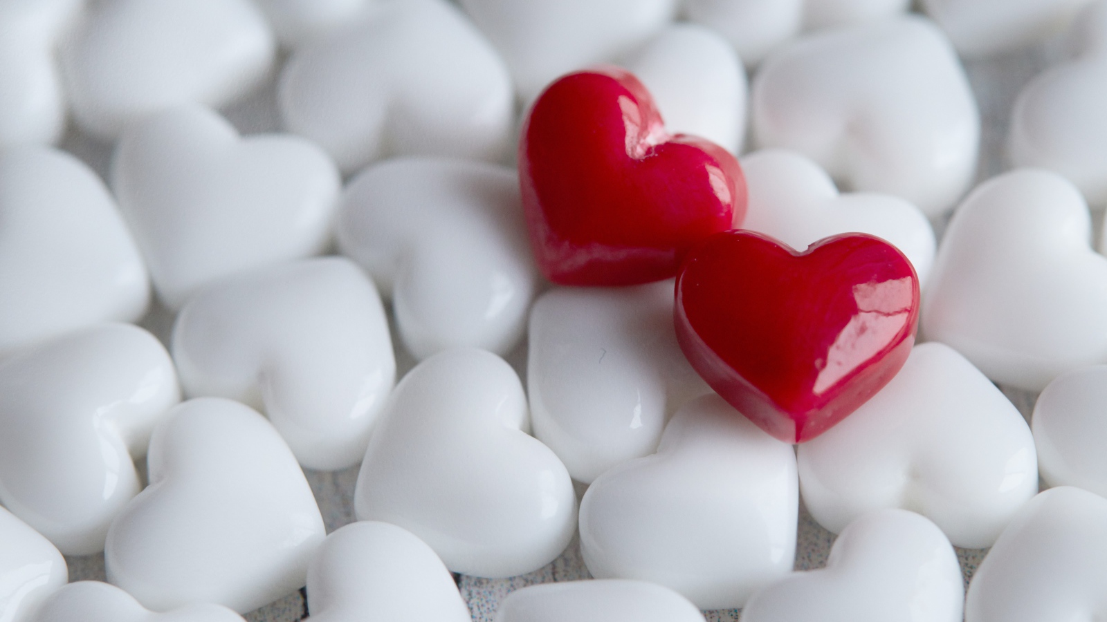 Два красных сердца лежат на белых 