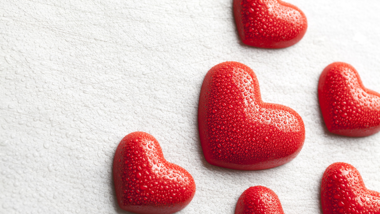 Мокрые красные сердечки на белом фоне