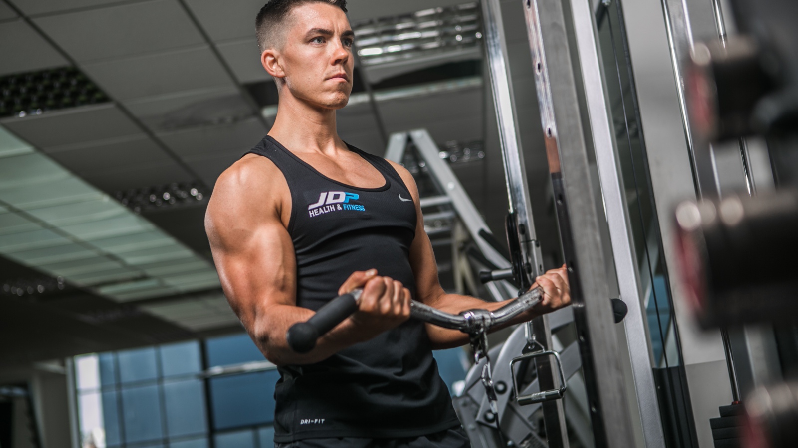 Накаченный мужчина занимается на тренажере в спортзале