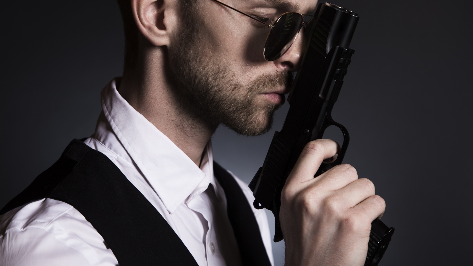 Man in glasses with a gun in his hand.