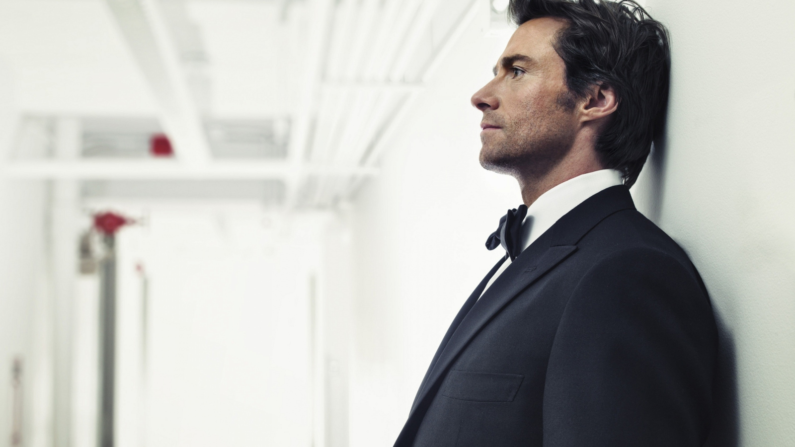 Мужчина в костюме, актер Хью Джекман у стены