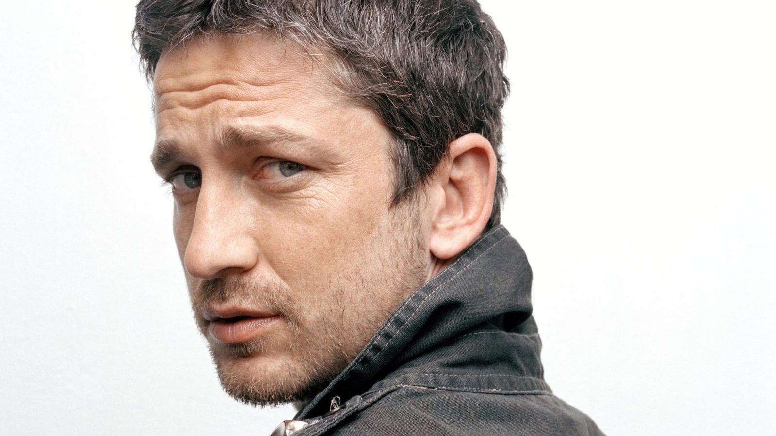 Актер Джерард Батлер крупным планом на белом фоне