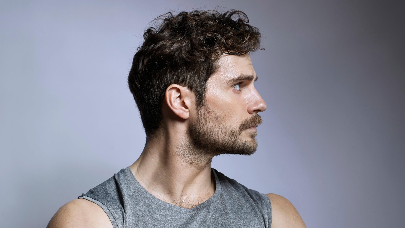 Красивый мужчина, актер Генри Кавилл на сером фоне