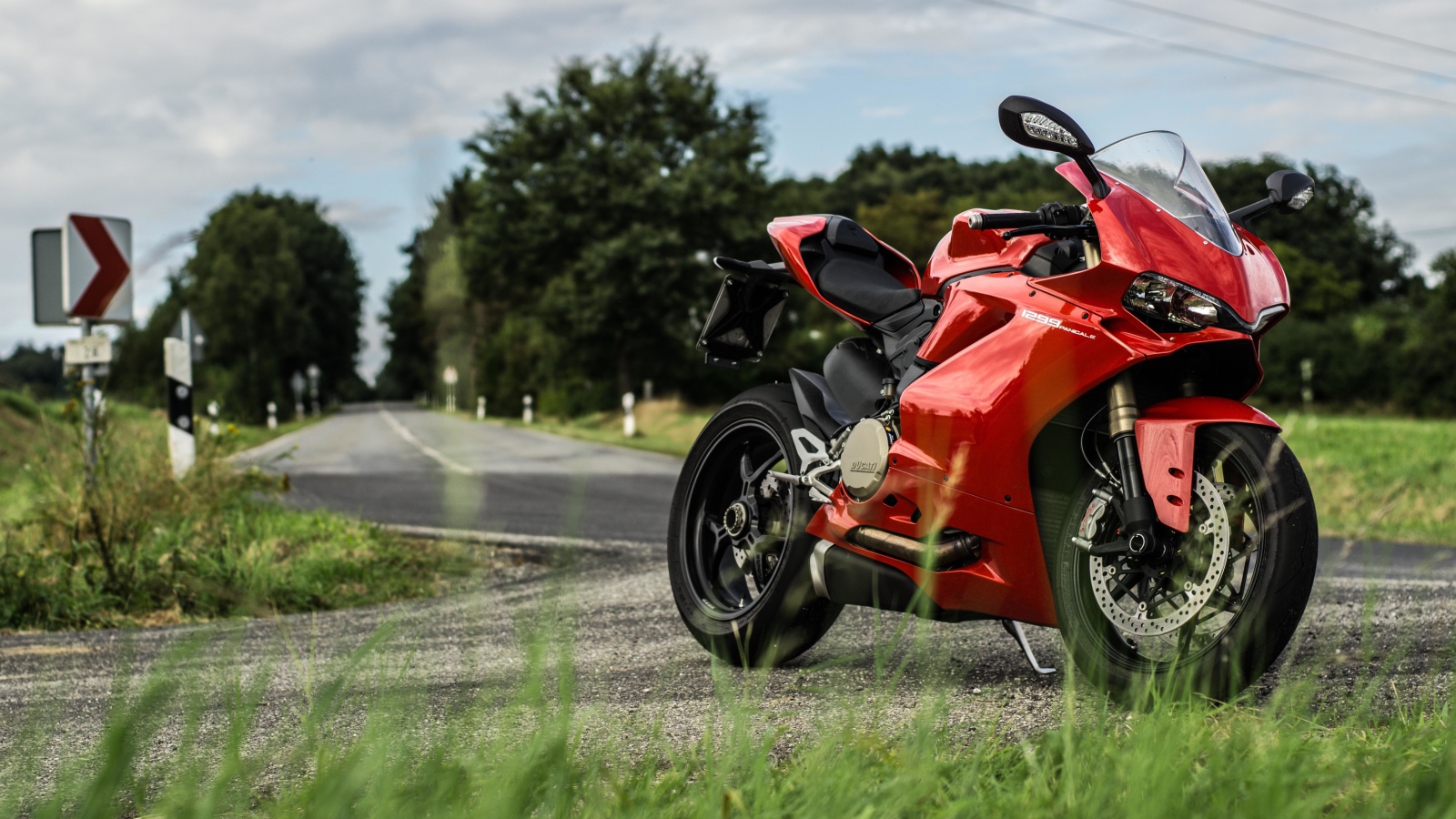 Красны мотоцикл Ducati 1299 Panigale на трассе 