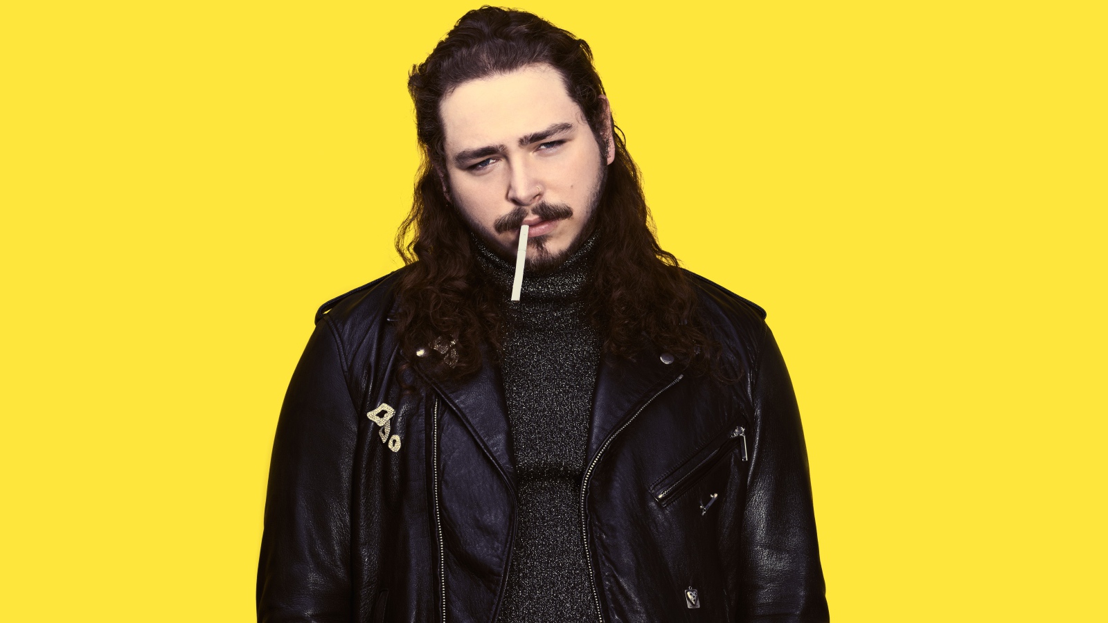 American rapper Post Malone in a black jacket on a yellow background