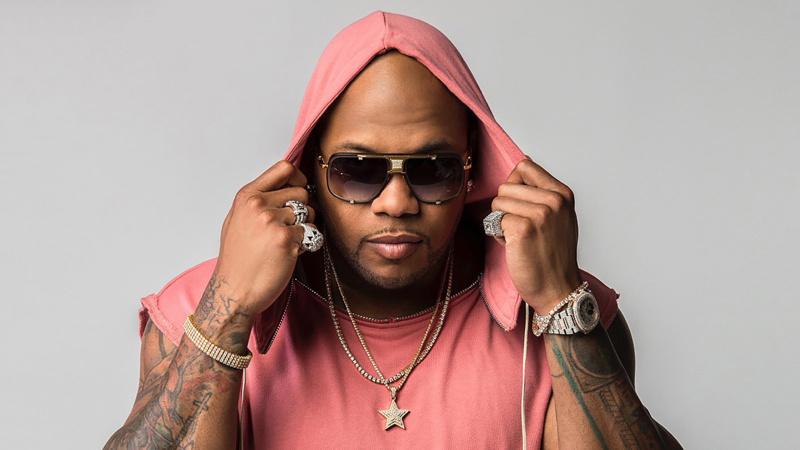 Рэпер Flo Rida на сером фоне