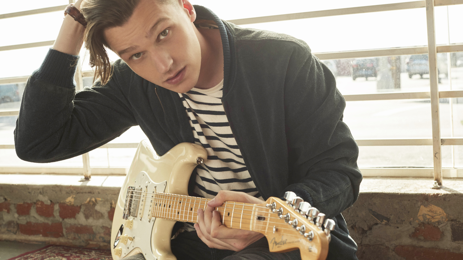 Певец Патрик Дрони с гитарой в руках