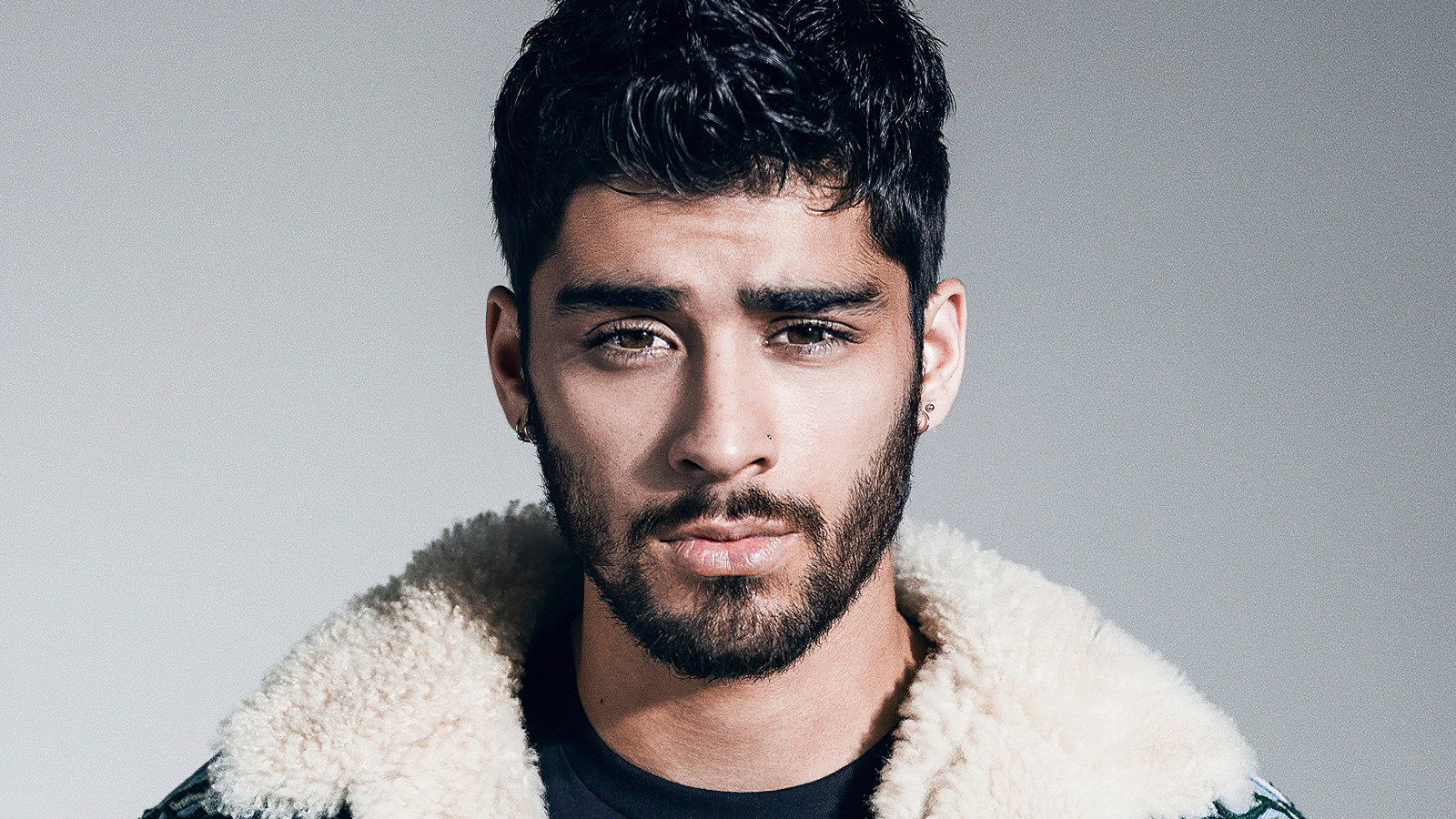 Молодой брюнет, певец Зейн Малик на сером фоне