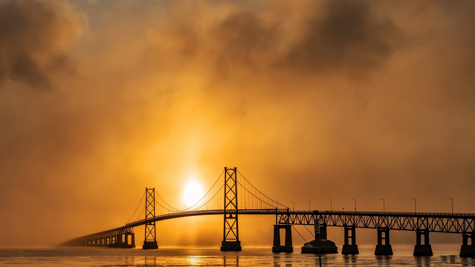 Мост через реку в тумане на восходе солнца