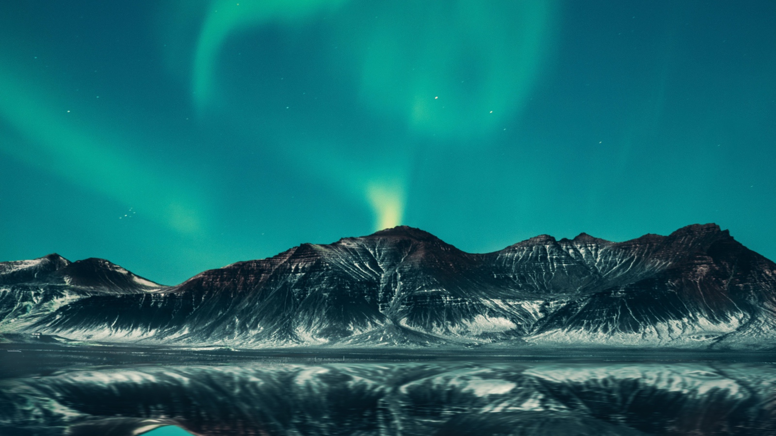 Зеленое северное сияние в небе над горами у озера 