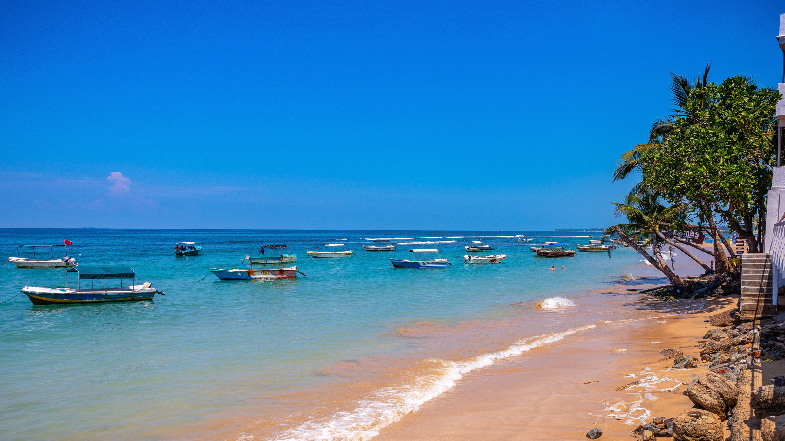 Лодки на берегу тропического пляжа на фоне голубого неба 
