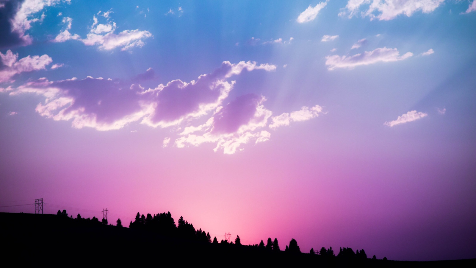 Красивое сиреневое небо с яркими лучами солнца