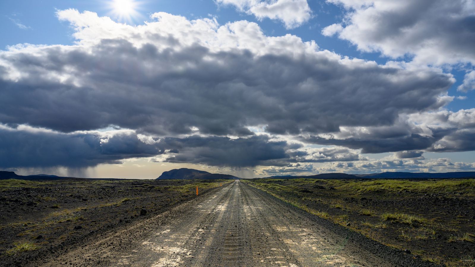 Длинная дорога под голубым солнечным небом с белыми облаками летом