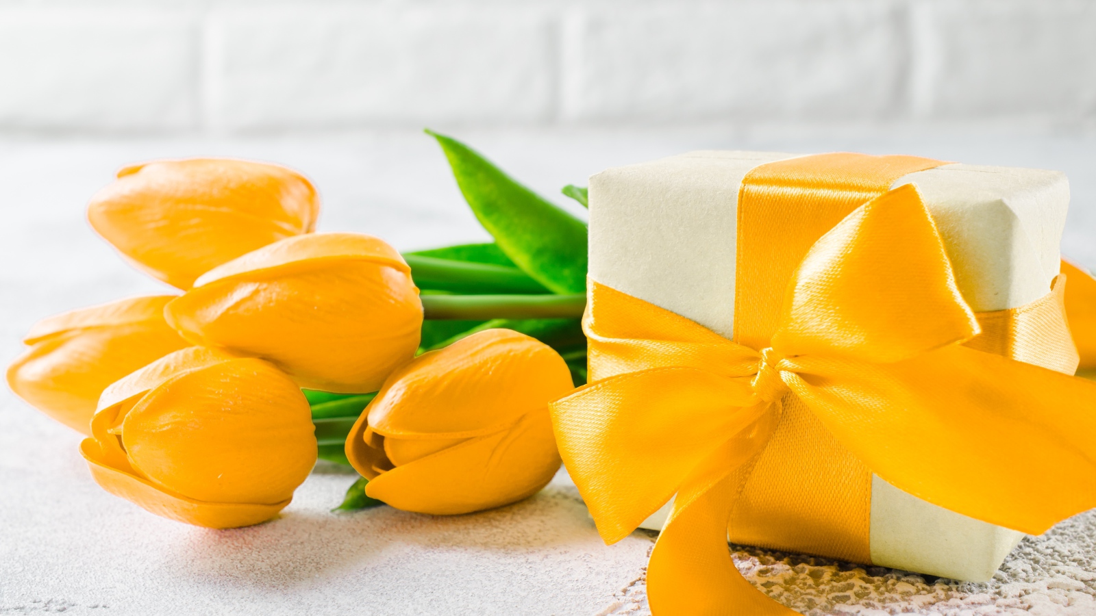 Красивый букет желтых тюльпанов с подарком