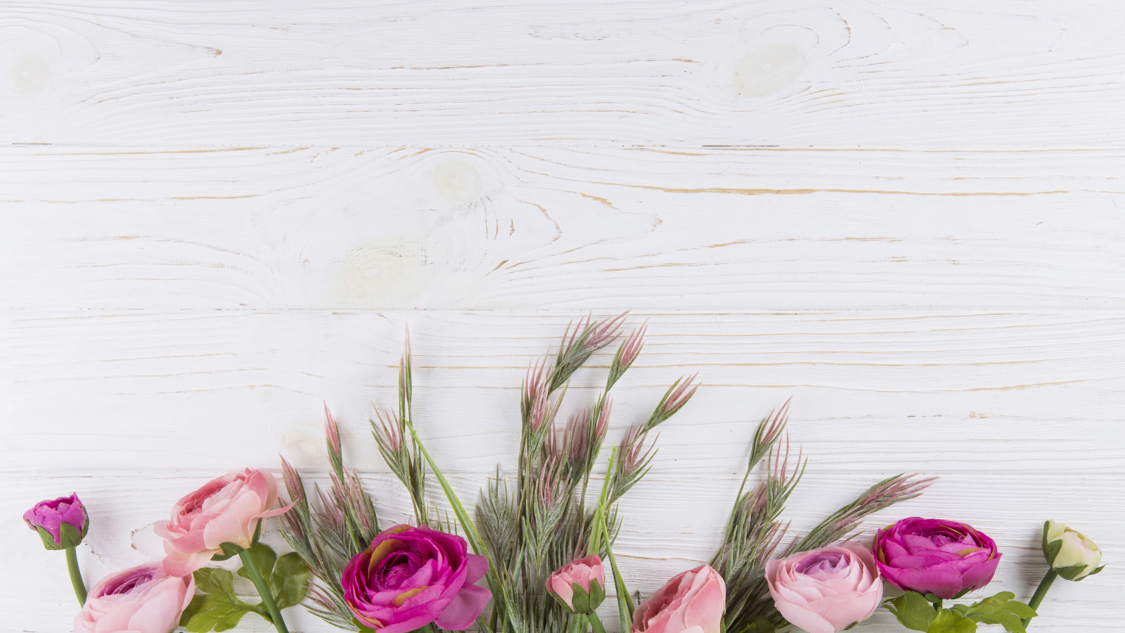 Букет разноцветных лютиков на белом столе