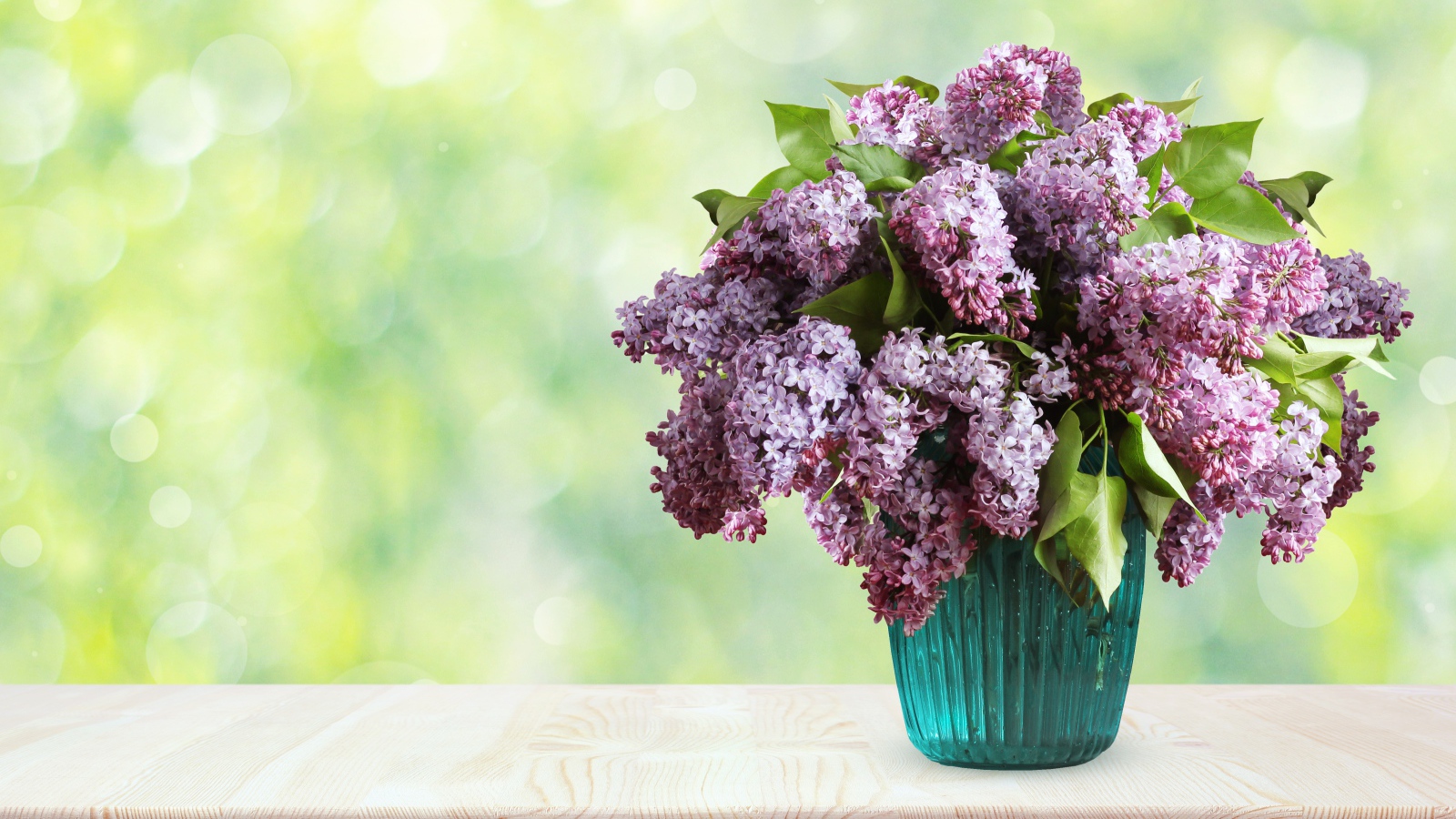 Букет ароматной сирени в вазе на столе