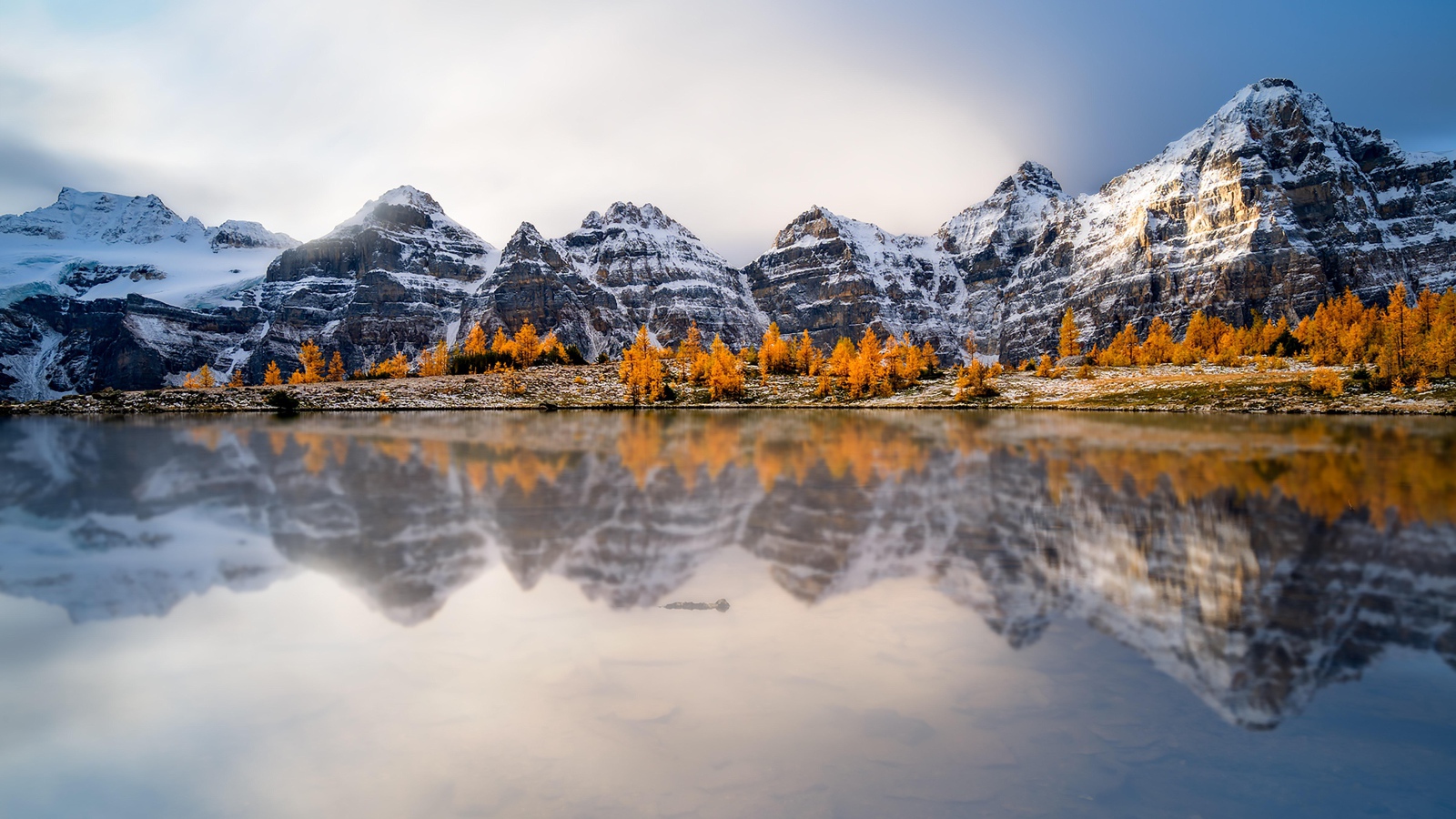 Заснеженные горы отражаются в воде озера 