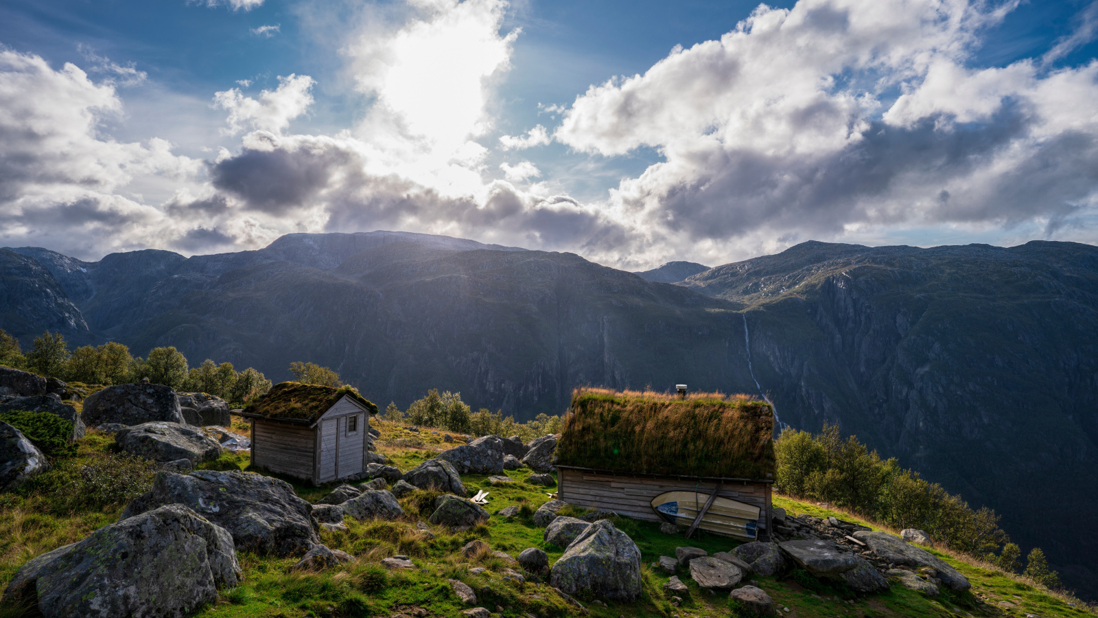 Солнце выглядывает из-за облаков в горах 