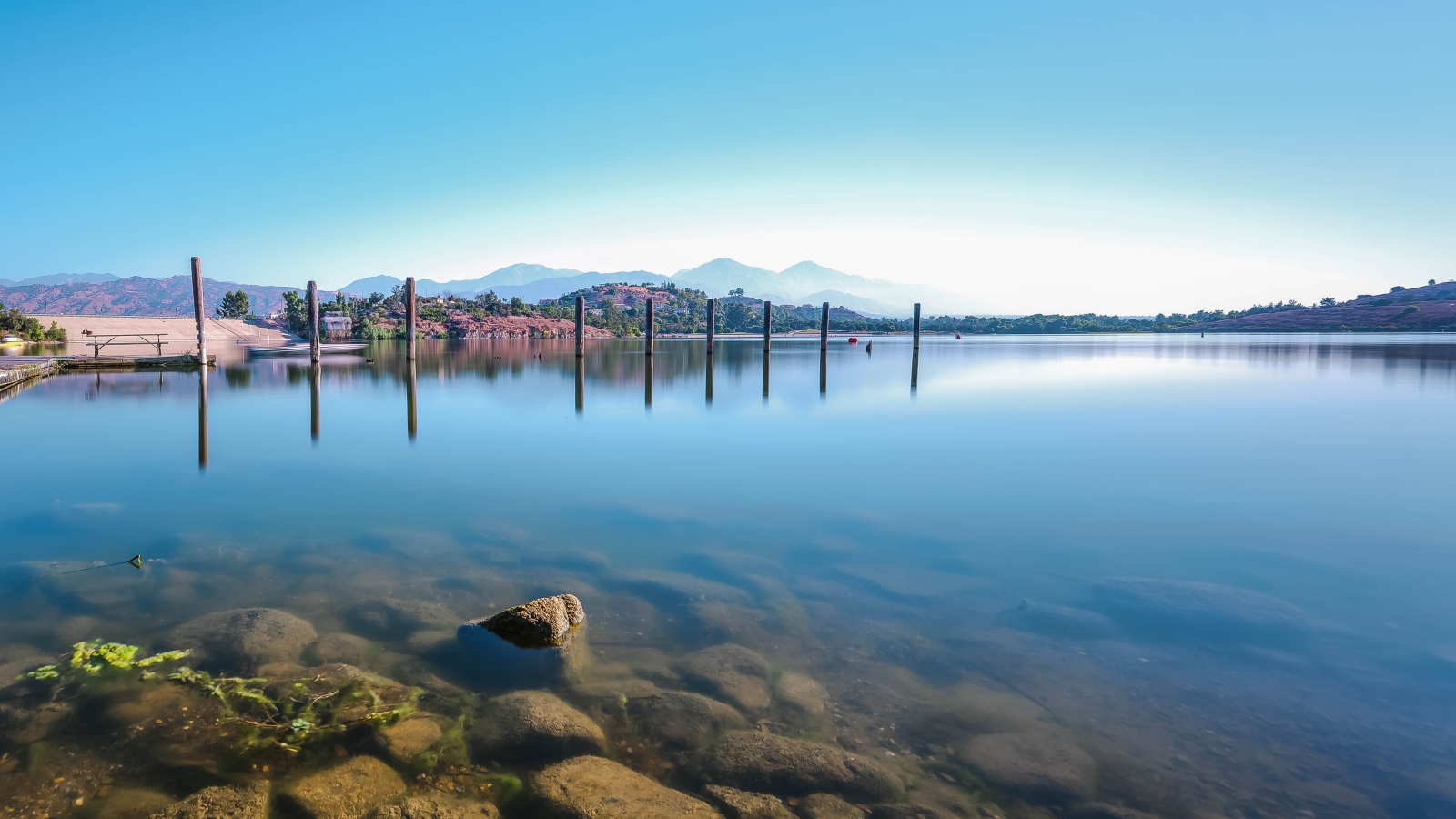 Камни в озере на фоне голубого неба