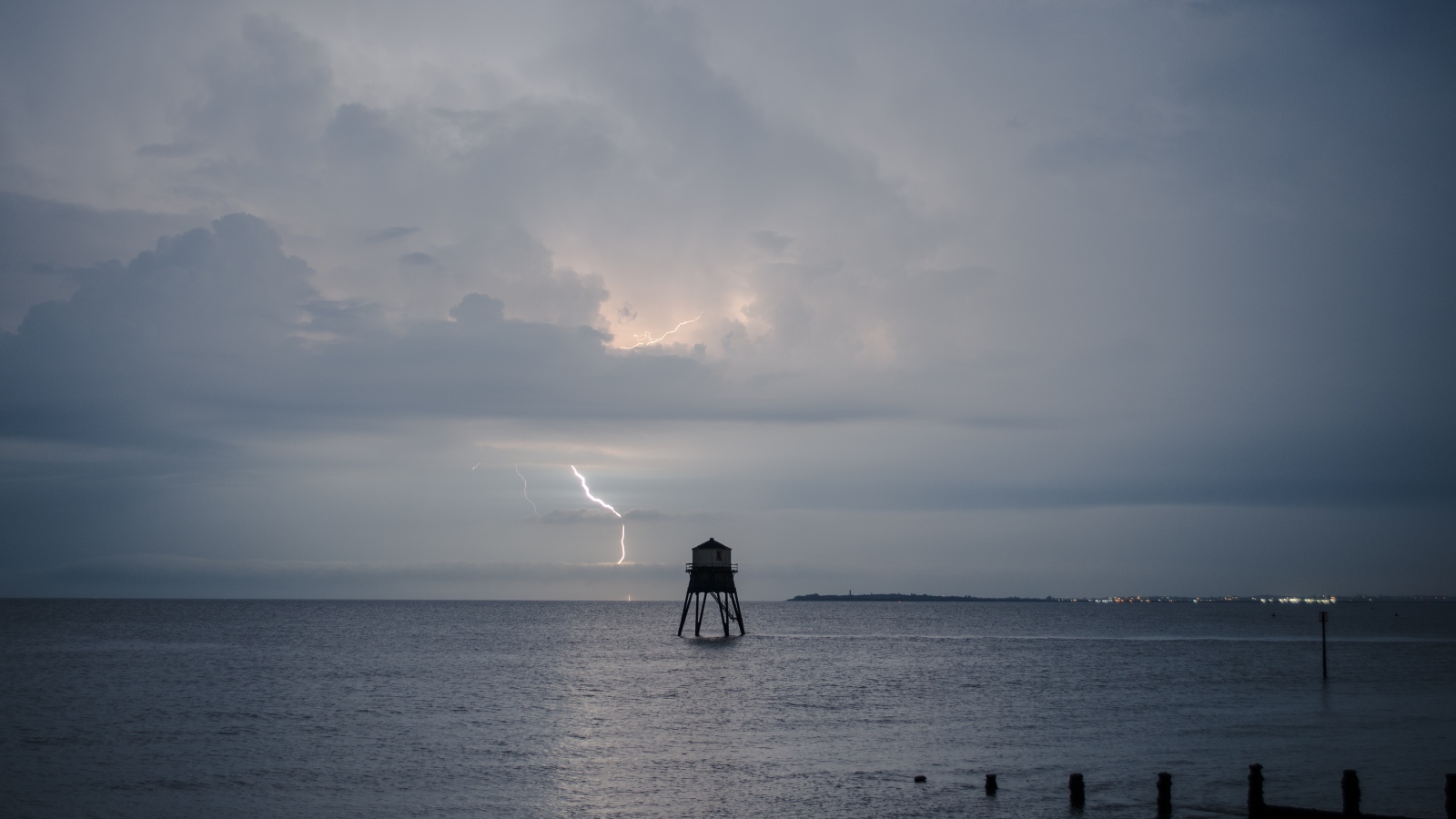 Старая башня в море на фоне грозы 