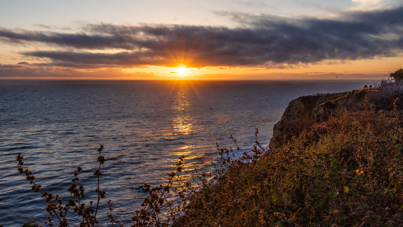Вид на закат солнца в темных облаках в небе над морем 
