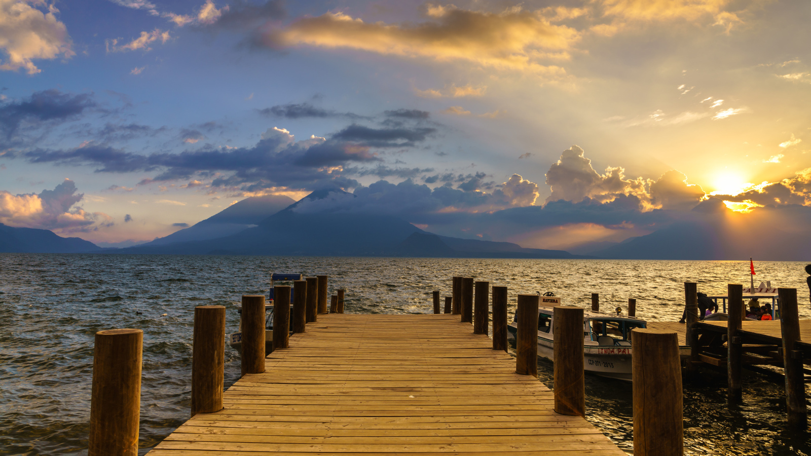 Деревянный мост в море на закате солнца 